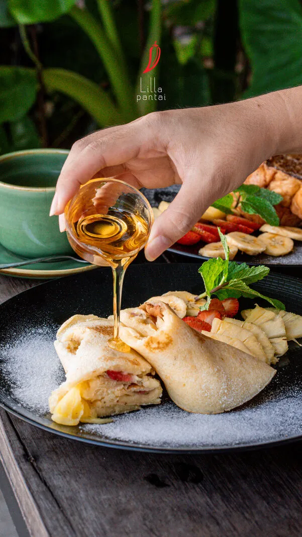 Honey being poured over a dessert at Lilla Warung